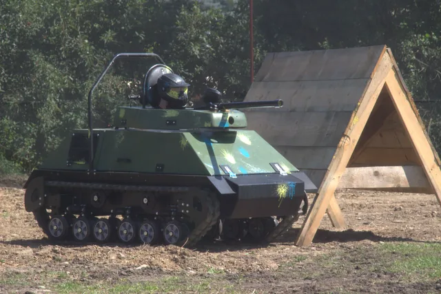 Mini czołg manewrujący przy drewnianej osłonie